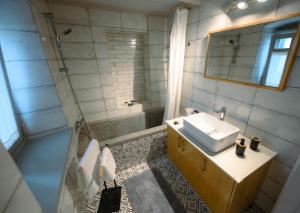 a bathroom with a sink and a shower and a mirror at Villa Calliope in Kalymnos