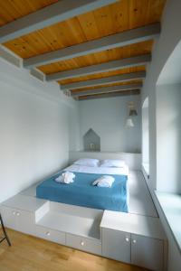 1 dormitorio con cama azul y techo de madera en Villa Calliope en Kalymnos