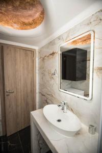 y baño con lavabo blanco y espejo. en Villa Amare en Porto Heli