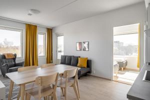 a living room with a table and a couch at Hiisi Homes Turku Ratapiha in Turku