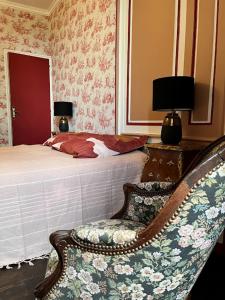 ein Schlafzimmer mit einem Bett, einem Stuhl und einer Lampe in der Unterkunft La tour cachée in Mortain
