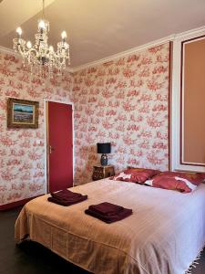 a bedroom with a large bed with pink wallpaper at La tour cachée in Mortain