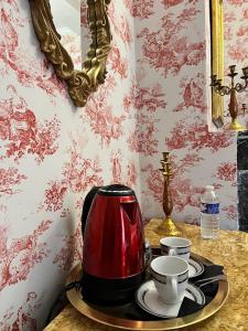 a red tea kettle on a tray on a table at La tour cachée in Mortain