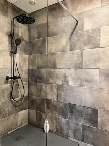 eine Dusche in einem Badezimmer mit einer Steinwand in der Unterkunft La tour cachée in Mortain + 28 Fotos