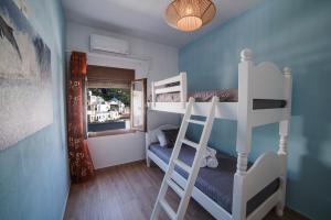 a room with two bunk beds and a ladder at koronos village apartments in Kóronos
