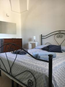 a bedroom with a bed and a dresser at La Racioppola in Ostuni