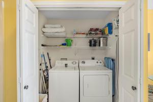 a small laundry room with a washer and dryer at The Dunes 502 by Vacation Homes Collection in Gulf Shores