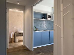 una cocina con armarios azules y fregadero en Ca' Magna Apartment en Venecia