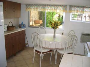 una cocina con una mesa con sillas y un jarrón de flores en Bella casa a la orilla del lago & estacionamiento en Tequesquitengo