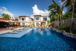 einen Pool mit Stühlen und ein Haus in der Unterkunft Árvo Boutique Hotel in Maragogi