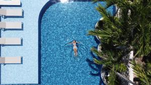 une femme est dans une piscine d'un complexe dans l'établissement Árvo Boutique Hotel, à Maragogi