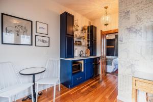 uma cozinha com armários azuis e uma mesa e cadeiras em The Matriarch- Downtown Ashland, OR em Ashland