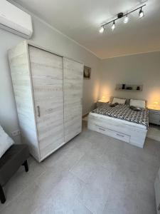 a bedroom with a bed and a large closet at Mira apartman in Zamárdi
