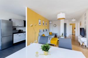 eine Küche und ein Wohnzimmer mit einem Tisch und einem Sofa in der Unterkunft Pineapple Apartments Dresden Altstadt III - 91 qm - 1x free parking in Dresden