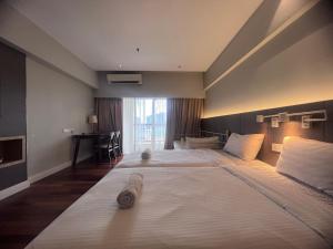 ペタリンジャヤにあるSunway Resort Suites By Newcityhomeのベッド2台とデスクが備わるホテルルームです。
