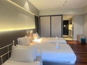 ペタリンジャヤにあるSunway Resort Suites By Newcityhomeのホテルルーム 白いシーツ付きのベッド2台付