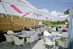 un patio con tavoli, sedie e ombrelloni di Hotel Wodnik a Breslavia