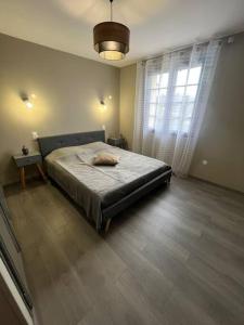 een slaapkamer met een bed en een groot raam bij Bâtisse Provençale in Gréoux-les-Bains