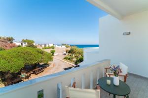 balcón con mesa y vistas al océano en Tselios Apartments & Studios en Kiotari