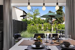 ein Esszimmer mit einem Tisch und einem Sonnenschirm in der Unterkunft Bungalow für 2 - Parkplatz - Küche - Terrasse in Speyer