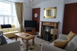 a living room with a couch and a fireplace at Spacious first floor family flat, Sea view in Torquay