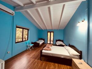 um quarto com paredes azuis e uma cama em Favela Chic Room em Durrës