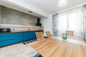 cocina con mesa de madera y armarios azules en Viccos Villa - Brand New Villa in Trou d'Eau Douce, en Trou d'Eau Douce