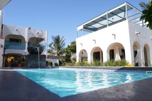 a villa with a swimming pool in front of a building at FINCA LUZ DEL MAR in Topolobampo