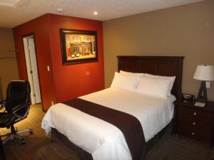 a hotel room with a bed and a chair at 121 Steakhouse & Motel in Assiniboia