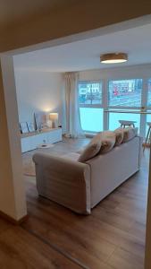 a bedroom with a white bed and a large window at L'Essentiel in Dinant