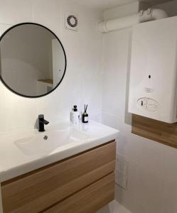 a bathroom with a white sink and a mirror at L'Essentiel in Dinant