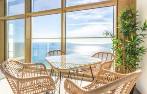 una mesa y sillas en un balcón con vistas al océano en INTEMPO SKY RESORT by Costa Activa Rentals, en Benidorm