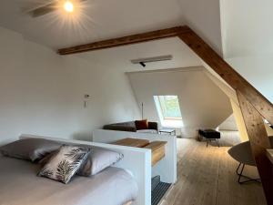 Un dormitorio con una cama blanca y una escalera en Het Generaaltje, en Hasselt