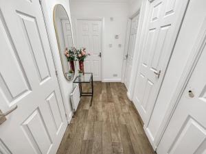 a hallway with white doors and flowers on a table at Comfortable 2 Bedroom Flat In The City Centre in Edinburgh