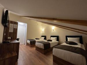 a hotel room with two beds and a television at Amber Hotel in Sarajevo