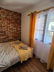a bedroom with a bed and a brick wall at Siedlisko PoMaLeńku in Żarnowska