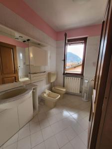 baño con aseo y lavabo y ventana en Casa la GlorioSa, en Gravellona Toce