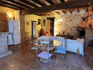 a kitchen and living room with a table and a refrigerator at Masia La Candelera in L'Ametlla de Mar