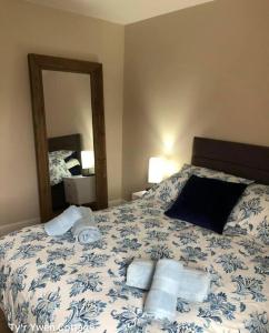 a bedroom with a bed with towels and a mirror at Tyr Ywen Cottage in Abergavenny