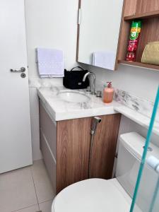 uma casa de banho com um lavatório, um WC e um espelho. em Apartamento Bauru em Bauru