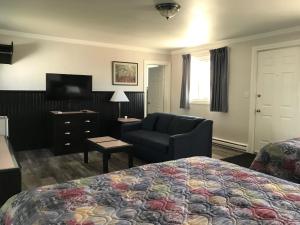 a hotel room with a bed and a chair at Tay Inn in Perth