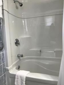 a bathroom with a white tub and a white towel at Tay Inn in Perth