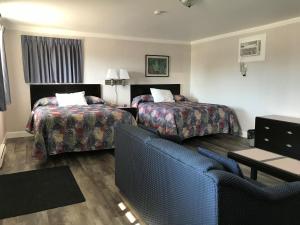 um quarto de hotel com duas camas e um sofá em Tay Inn em Perth