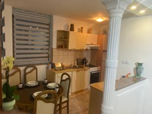 a kitchen with a table and chairs and a kitchen with a column at Hana in Konjic