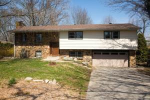 a stone house with a garage in a yard at 6 Bedrooms house, w/Hot Tub, Deck, Pool Table in Bloomington