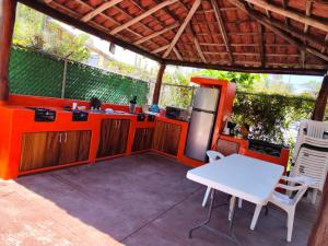 uma cozinha exterior com uma mesa branca e cadeiras em Hotel J.B. em Zihuatanejo