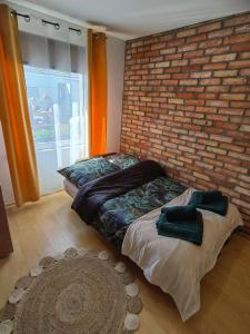 a bedroom with a brick wall and a bed at Siedlisko PoMaLeńku in Żarnowska