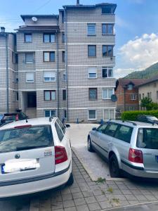 two cars parked in a parking lot in front of a building at Hana in Konjic
