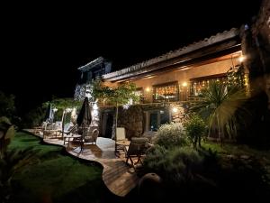 a house with a patio at night at Hôtel Ambassador Palombaggia in Porto-Vecchio