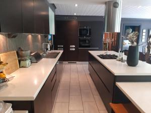 a kitchen with dark brown cabinets and white counter tops at Stryn Sentrum 3 soverom in Stryn